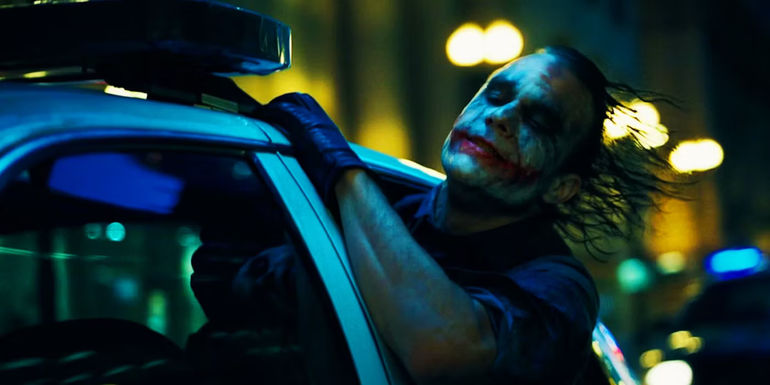 The Joker hanging out of a car in The Dark Knight