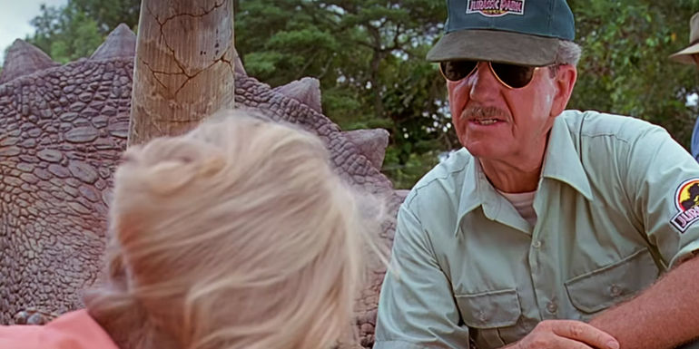 Gerry Harding stands next to a triceratops and looks at Ellie Sattler in Jurassic Park.