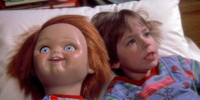 Chucky lays next to Alex Vincent as Andy in Child's Play
