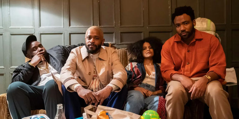 Cast of Atlanta sitting on a chair