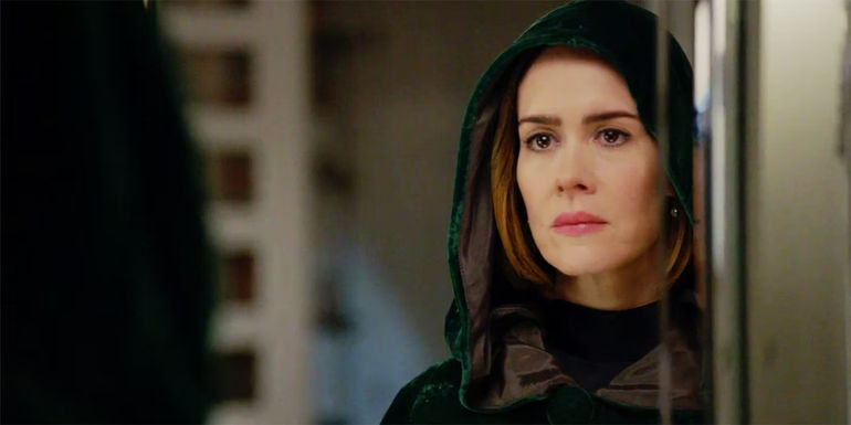 Sarah Paulson as Ally wearing a cloak looking the mirror in American Horror Story season 7