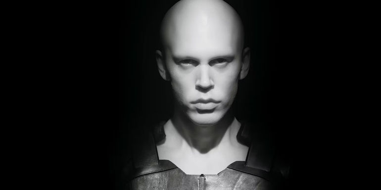 Austin Butler ghostly pale and gazing blank faced from the shadows in a dramatic scene from Dune: Part Two