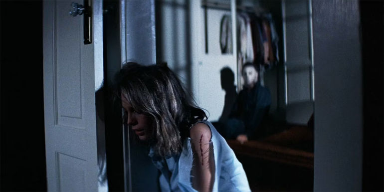 Jamie Lee Curtis as Laurie is injured while Michael gets back up behind her in Halloween (1978)