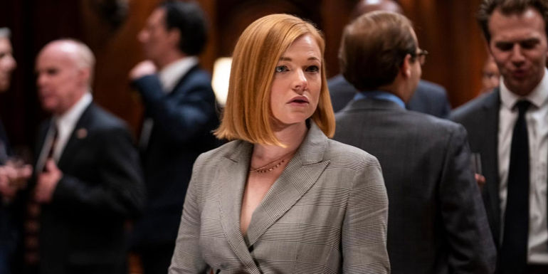 Shiv looks in the distance at a crowded party in Succession.