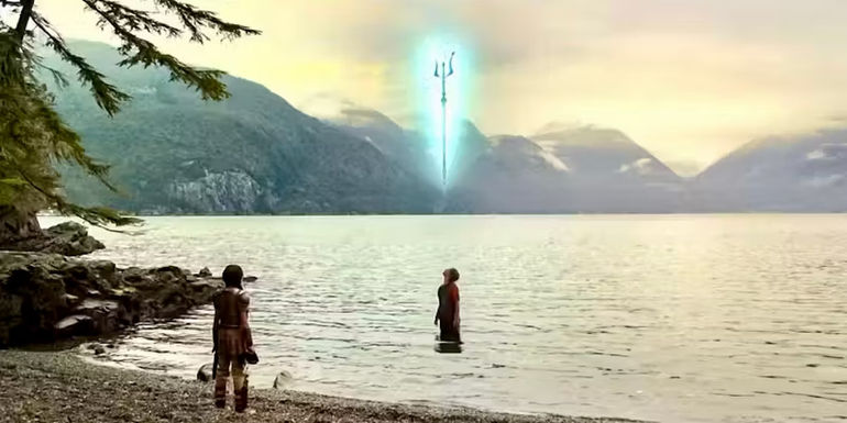 Percy Jackson is standing in the water looking up with Poseidon's trident above him. Annabeth watches from the shoreline in Percy Jackson and the Olympians.