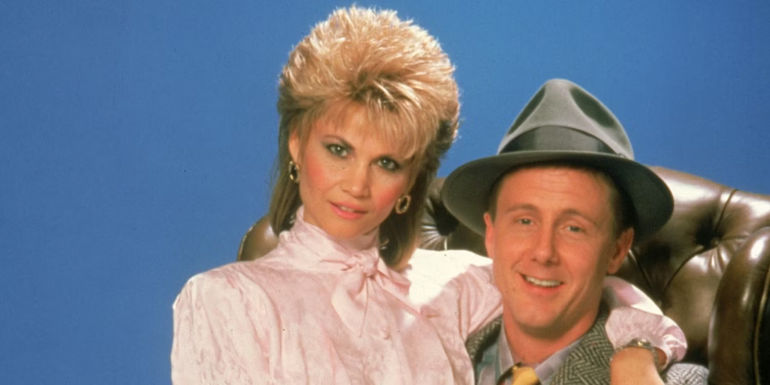 Christine sitting on Harry's lap in Night Court