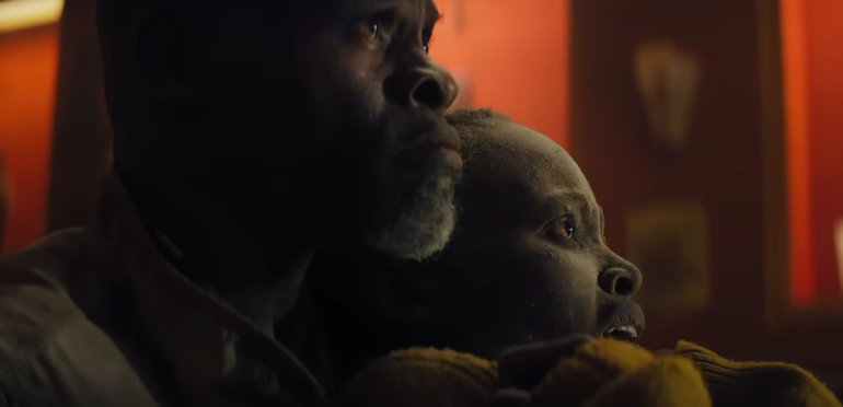 Djimon Hounsou's Man on Island holds Lupita Nyong'o's Sam in A Quiet Place: Day One