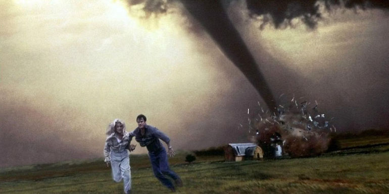 Bill Paxton's Bill and Helen Hunt's Jo run from a tornado that is destroying a house in Twisters