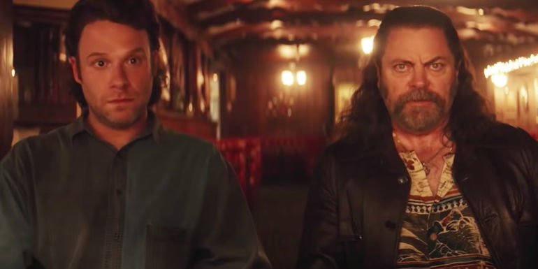 Seth Rogen and Nick Offerman sitting at a table and looking nervous in Pam & Tommy