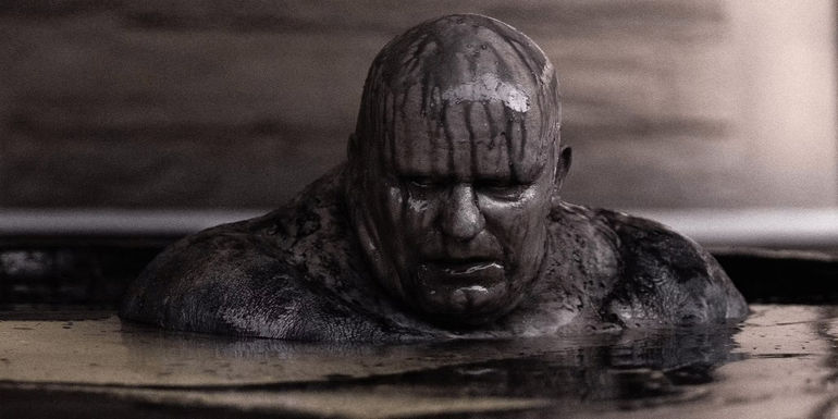 Baron Harkonnen emerges from a black oil bath in Dune.