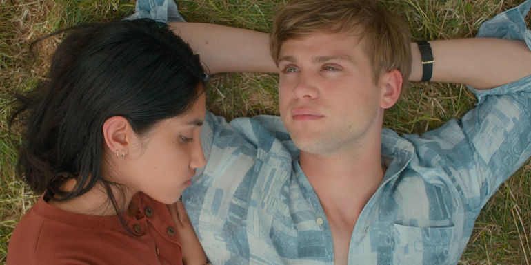 Em and Dex lie together on the grass in One Day series