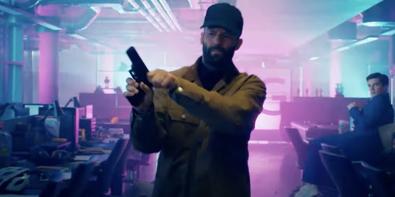 Jason Statham cocking a handgun in The Beekeeper