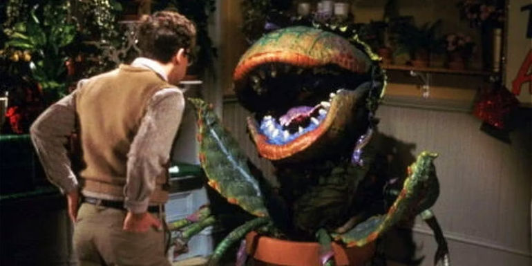Seymour (Rick Moranis) looking at Audrey II in Little Shop of Horrors