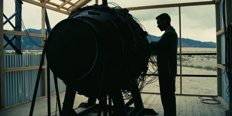 Cillian Murphy as Oppenheimer standing with atomic bomb in Oppenheimer movie