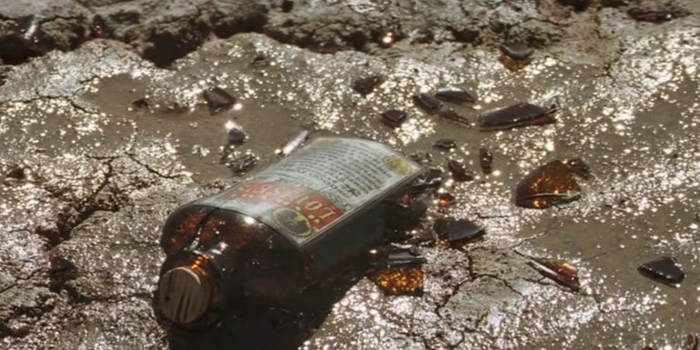 A bottle of Madame Louise's (Anjelica Huston) curative smashed against the desert ground in Seraphim Falls