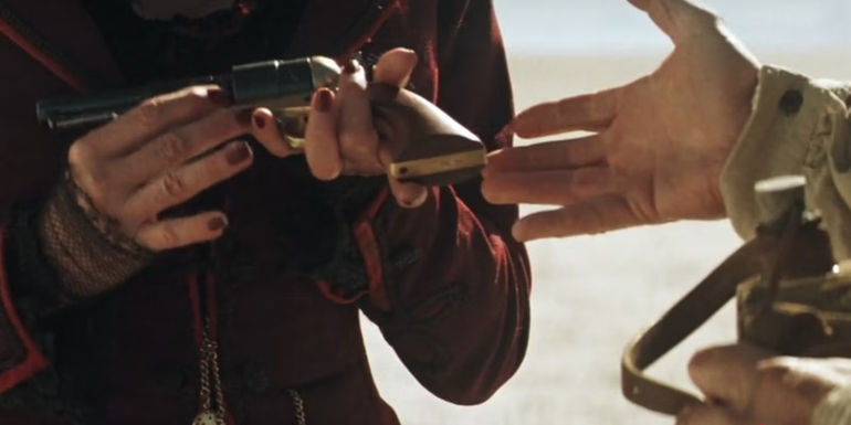 Carver (Liam Neeson) reaches for Madame Louise's pistol, trading it for his water in Seraphim Falls