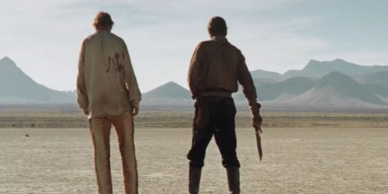 Carver (Liam Neeson) and Gideon (Pierce Brosnan) walk away from their final fight in the desert at the end of Seraphim Falls