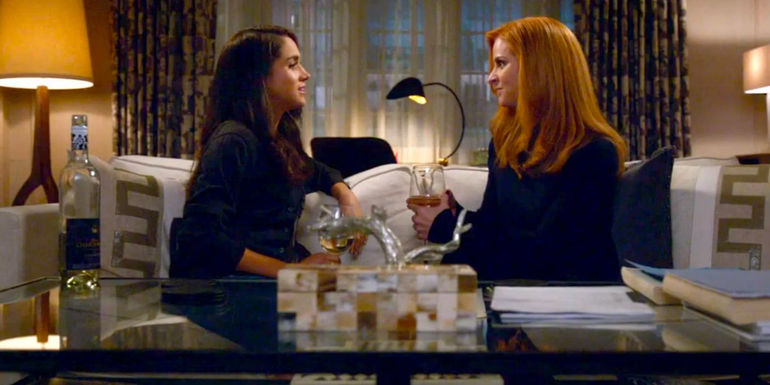 Rachel Zane (Megan Markle) and Donna Paulsen (Sarah Rafferty) sitting across from each other on a couch in Suits