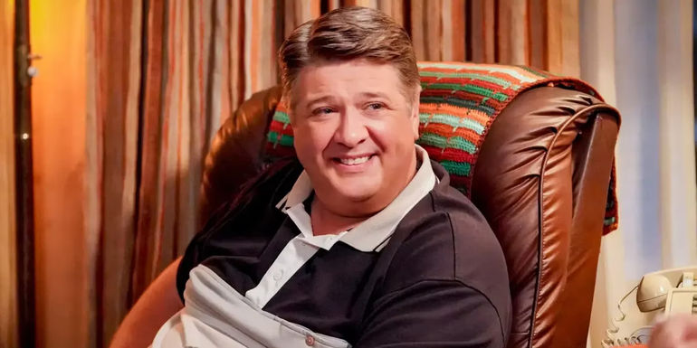 Lance Barber's George Cooper in a chair in Young Sheldon