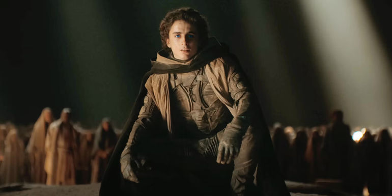 Timothée Chalamet as Paul stooping in front of Fremen in Dune Part Two