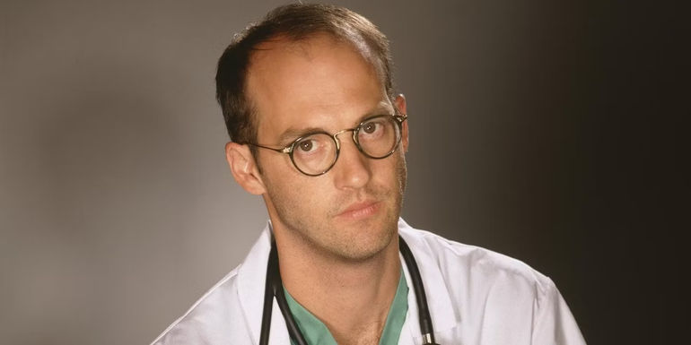 Anthony Edwards as Dr. Mark Greene in front of a gray background in ER