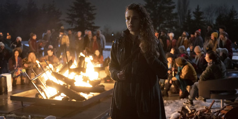 Callie Cadogan near a fire with many people behind her in The 100 backdoor pilot for a prequel series
