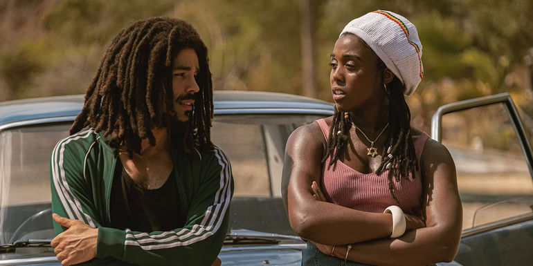 Bob Marley and Rita lean against a car in Bob Marley One Love
