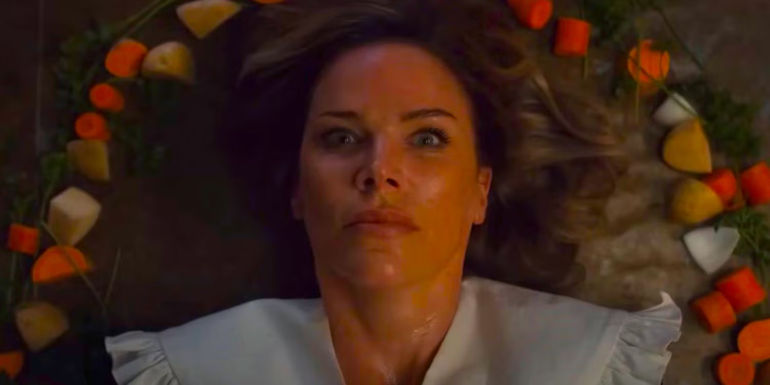 A victim looking scared surrounded by carrots and potatoes in Eli Roth's Thanksgiving