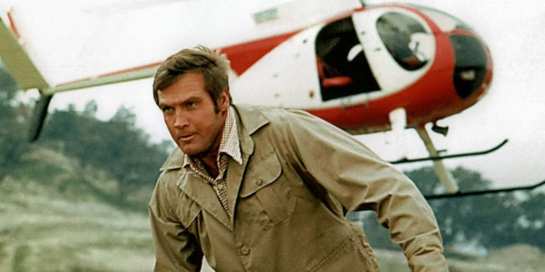 Lee Majors in the Six Mllion Dollar Man standing in front of helicopter