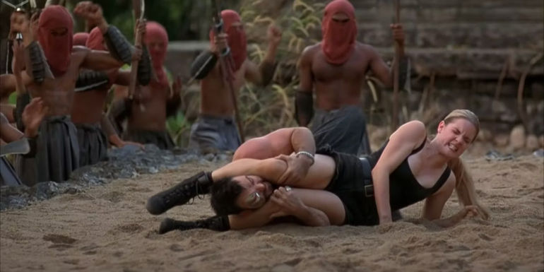 Bridgette Wilson as Sonya Blade fighting Trevor Goddard as Kano in the sand in Mortal Kombat (1995)