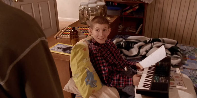 Dewey lying on his bed with a keyboard in his lap in Malcolm in the Middle
