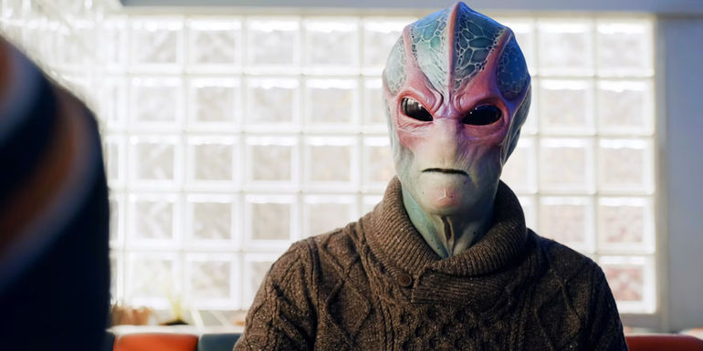 Dr. Vanderspeigle sitting in diner in alien form in Resident Alien