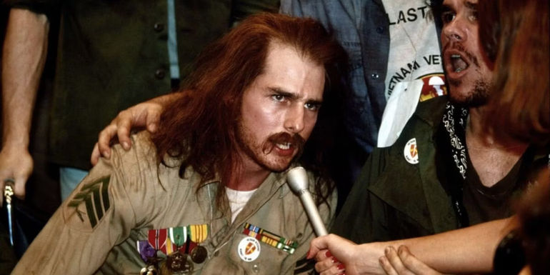 Tom Cruise speaking on a mic in Born on the Fourth of July