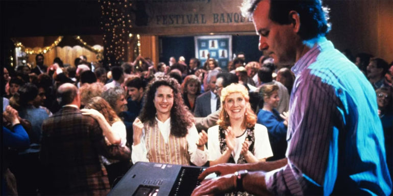 Phil (Bill Murray) plays the piano onstage as Rita (Andie MacDowell) watches from the crowd in Groundhog Day. - Harold Ramis initially said 10 years, but later retracted his statement - Even Groundhog Day's Director Doesn't Know How Long Phil Was Trapped