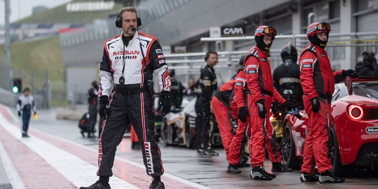 David Harbour as Jack Salter walking on the pit lane in Gran Turismo