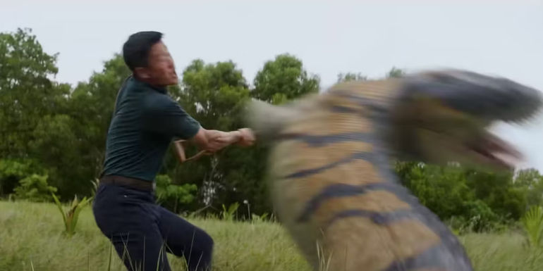 Jiuming hits a dinosaur with a shovel in Meg 2 The Trench