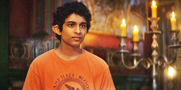 Aryan Simhadri as Grover wearing an orange Camp Half-Blood shirt in Percy Jackson and the Olympians