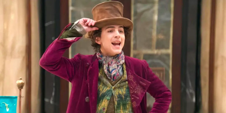 Timothée Chalamet as Willy Wonka holding his hat in Wonka