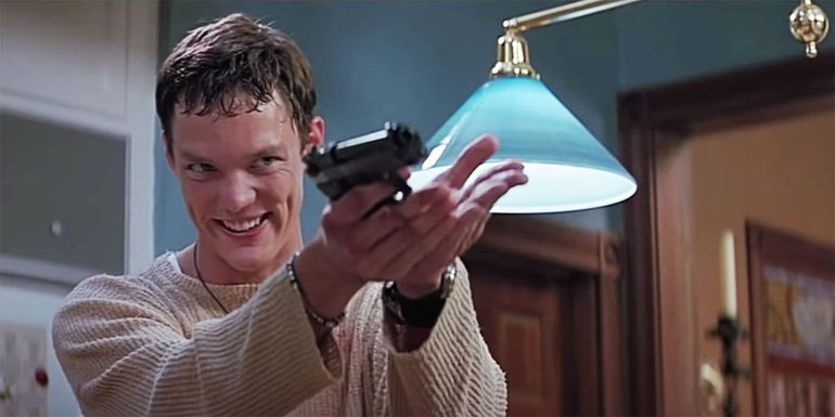 Stu Macher smiling and holding up a gun in Scream
