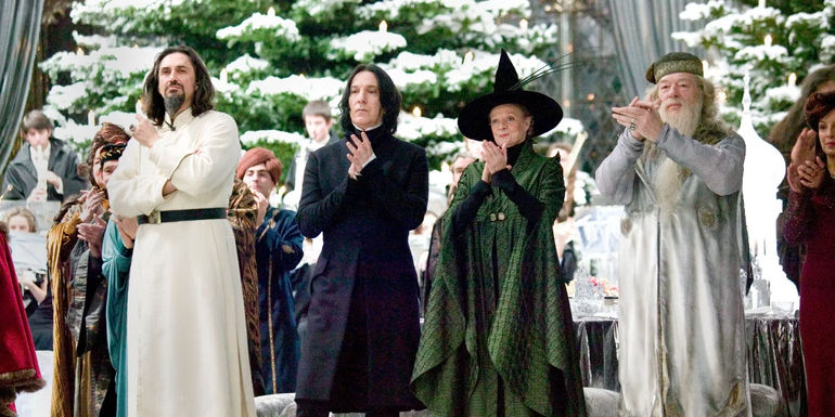 Karkaroff, Snape, McGonagall, and Dumbledore applaud in front of a Christmas tree in Harry Potter and the Goblet of Fire.