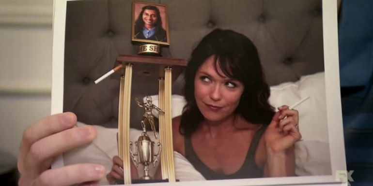 Jenny (Katie Aselton) in bed with the Shiva trophy in The League.