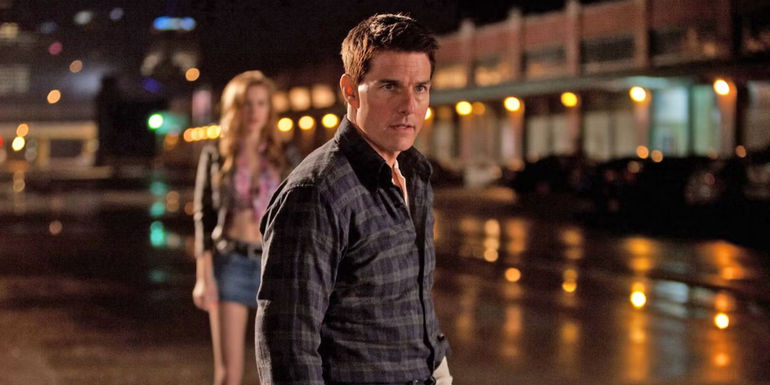Tom Cruise as Jack Reacher with an out-of-focus woman in the background in the 2012 movie