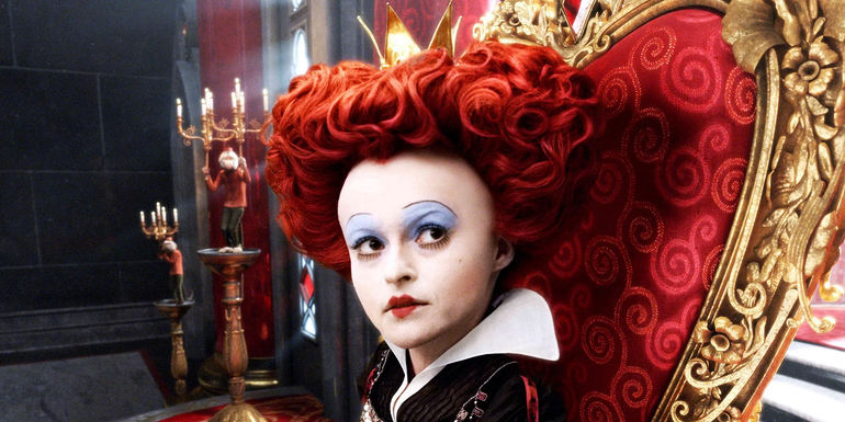 Helena Bonham Carter as the Red Queen sitting in her throne in Alice in Wonderland.