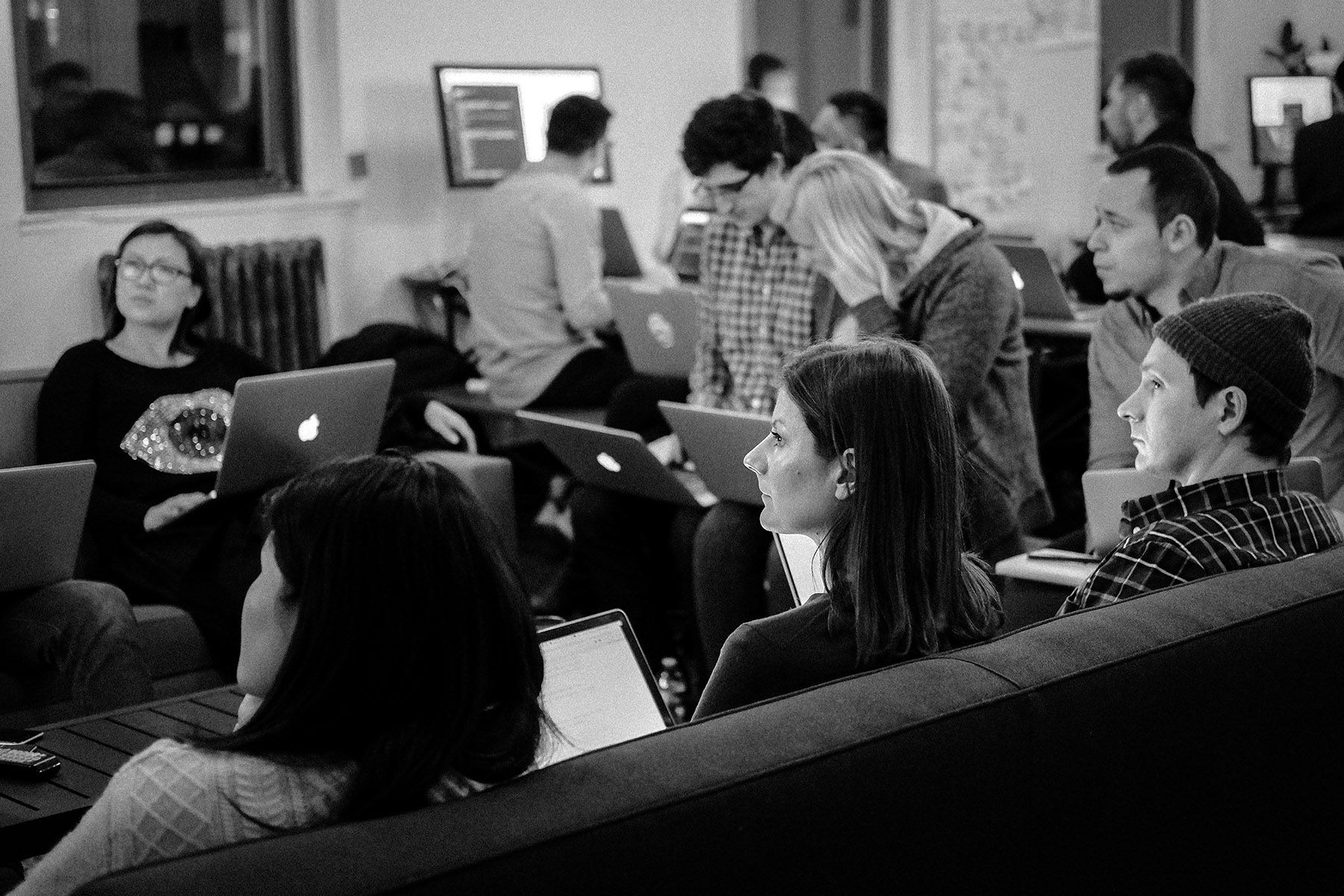 A group of people at a meet up, watching a presentation
