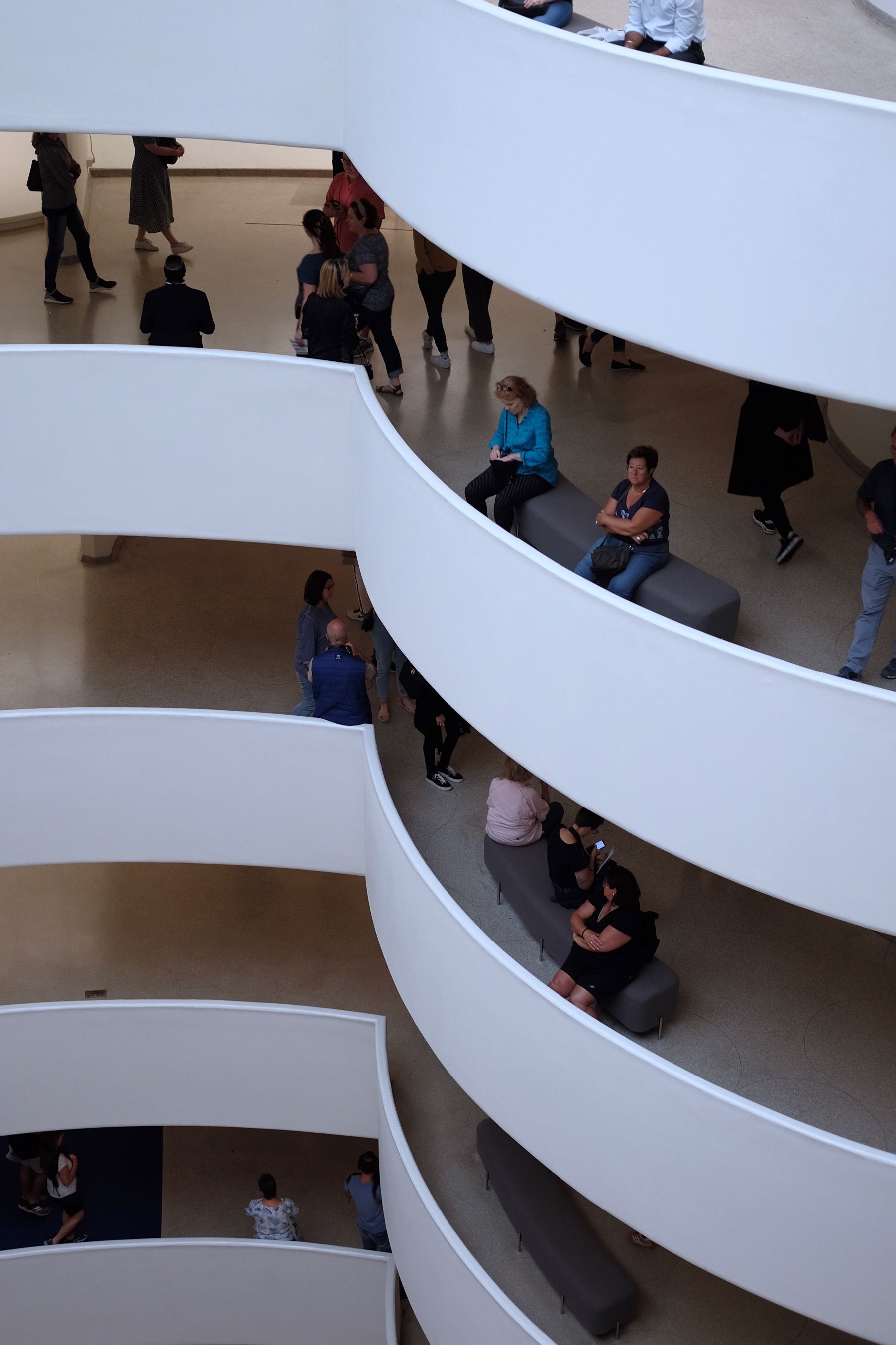 Two ladies with their arms folded, one level apart.