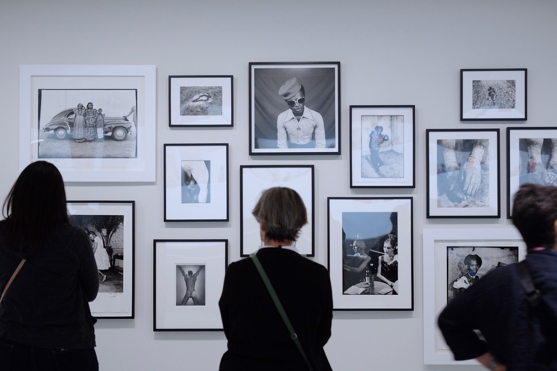 A lady looking at a series of portraits, with her back to the camera.