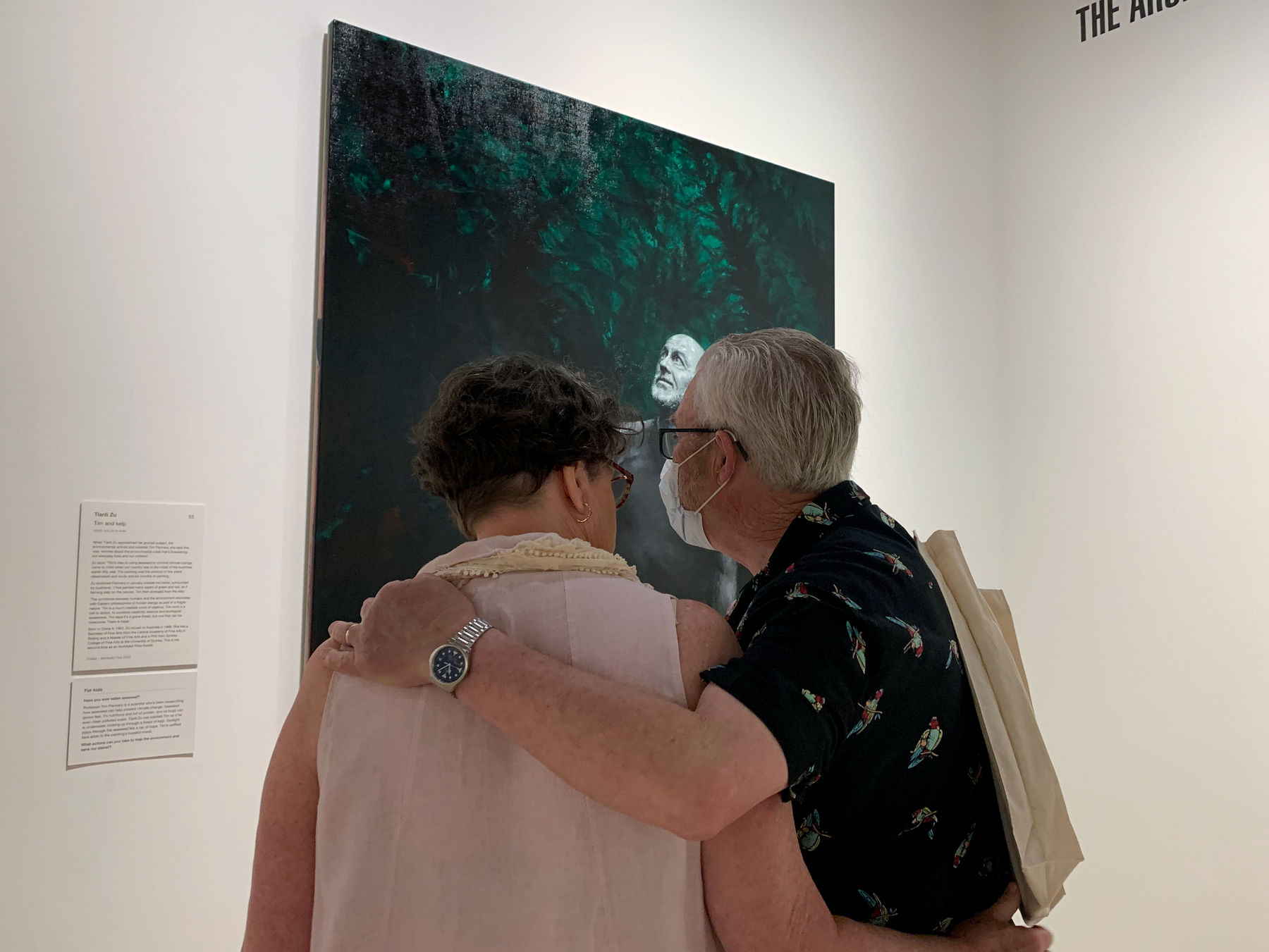 A couple looking at an artwork whilst cuddling