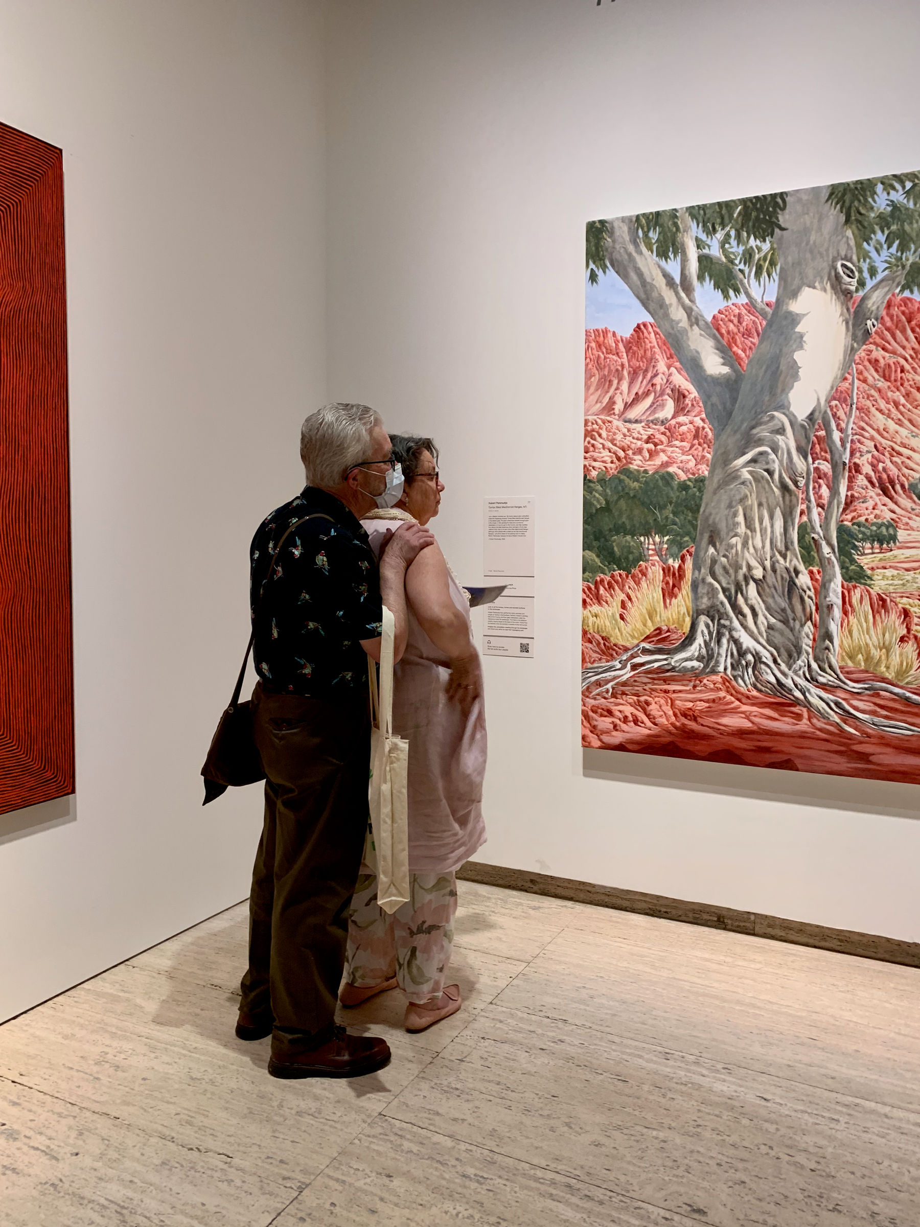 A couple looking at an artwork whilst cuddling