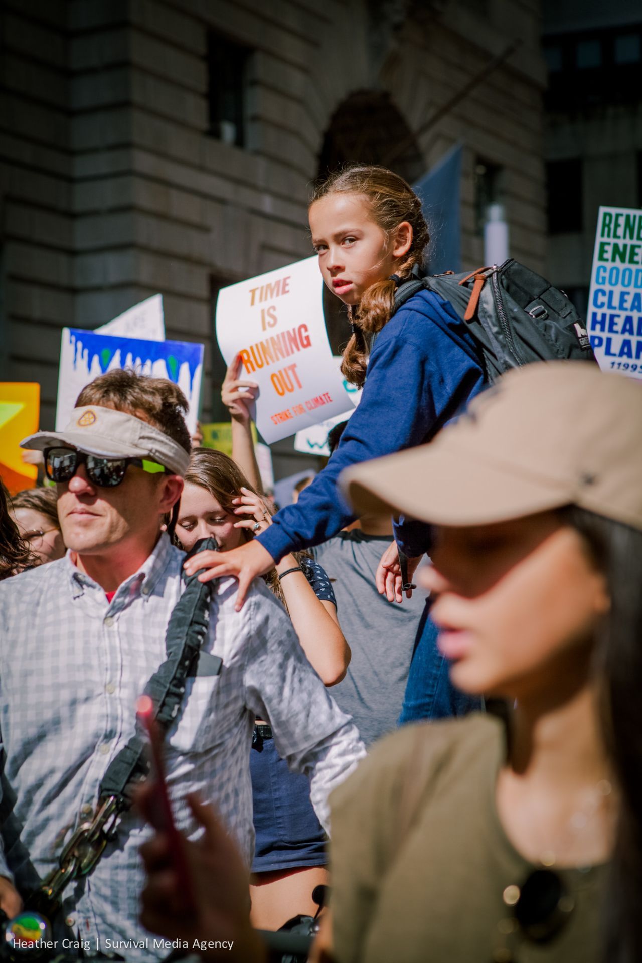 Girl at Climate Strike with 'Time is Running Out' poster behind her