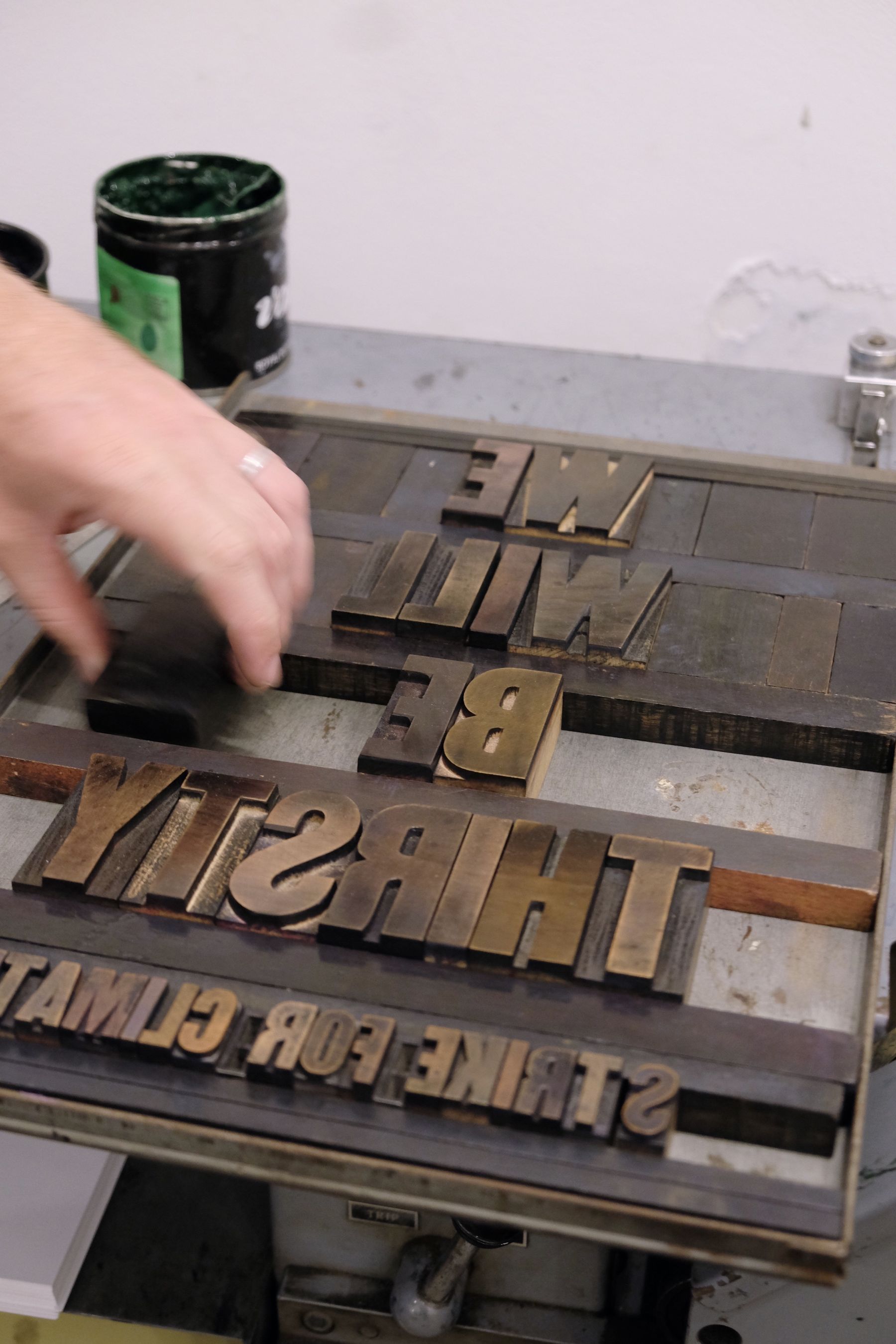 A hand arranging type on a plate, in preparation for printing